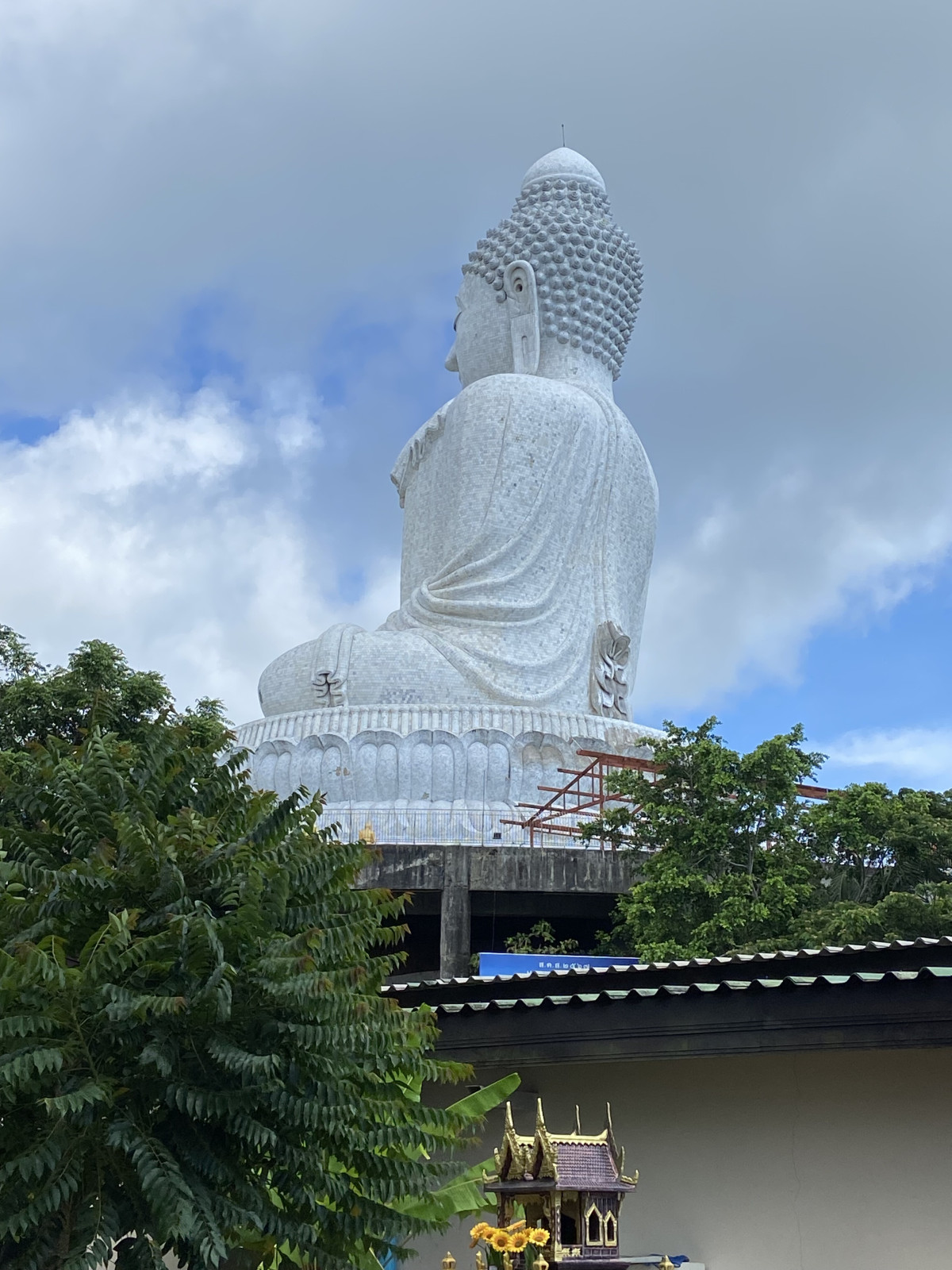 A majestic view of the Big Buddha in Phuket, Thailand, standing tall against a bright, cloudy sky